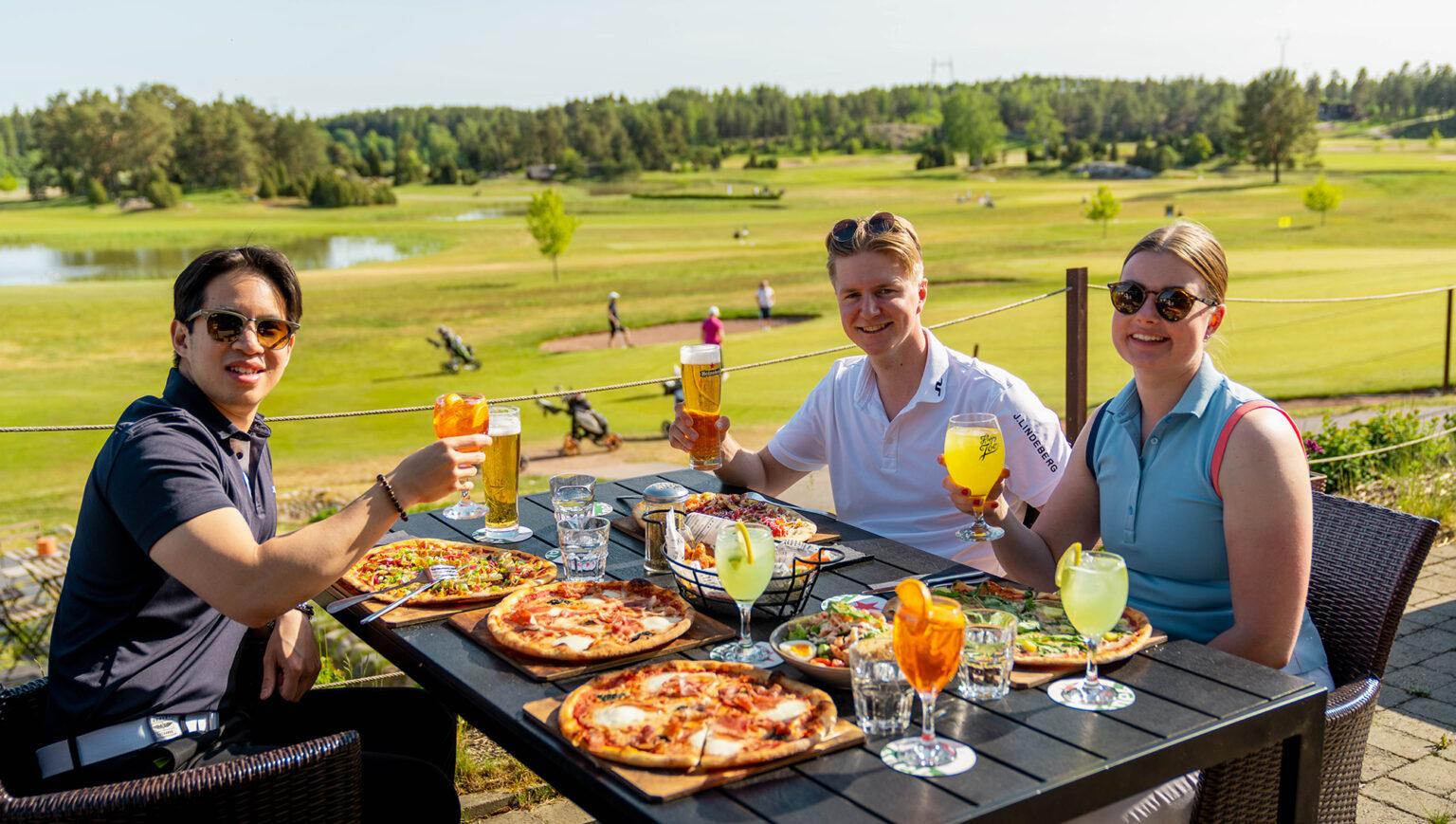Guests dining on the Heineken House terrace overlooking the golf course at Kultaranta Resort