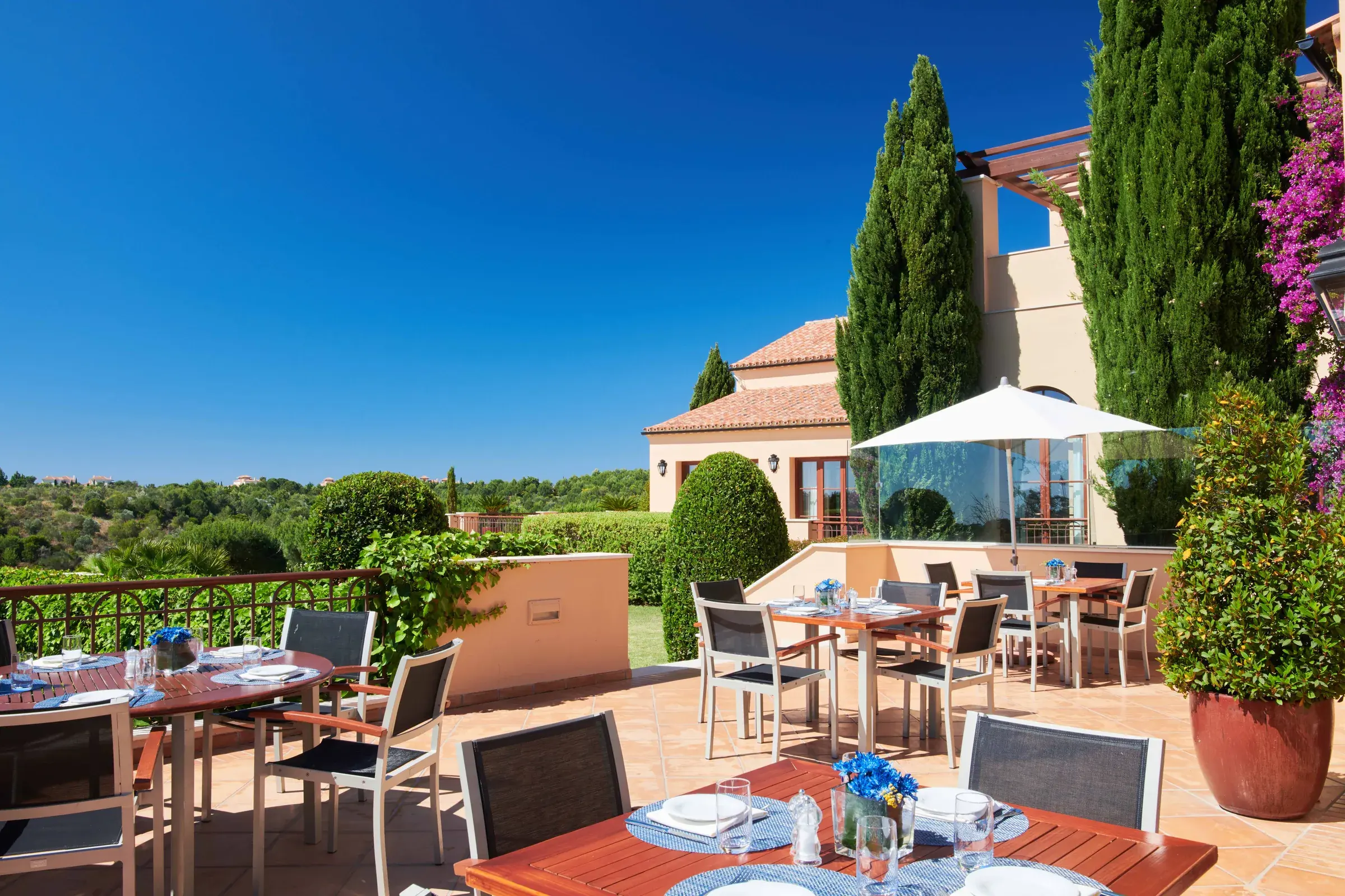 Dining tables on The Grill terrace overlooking Monte Rei’s golf course