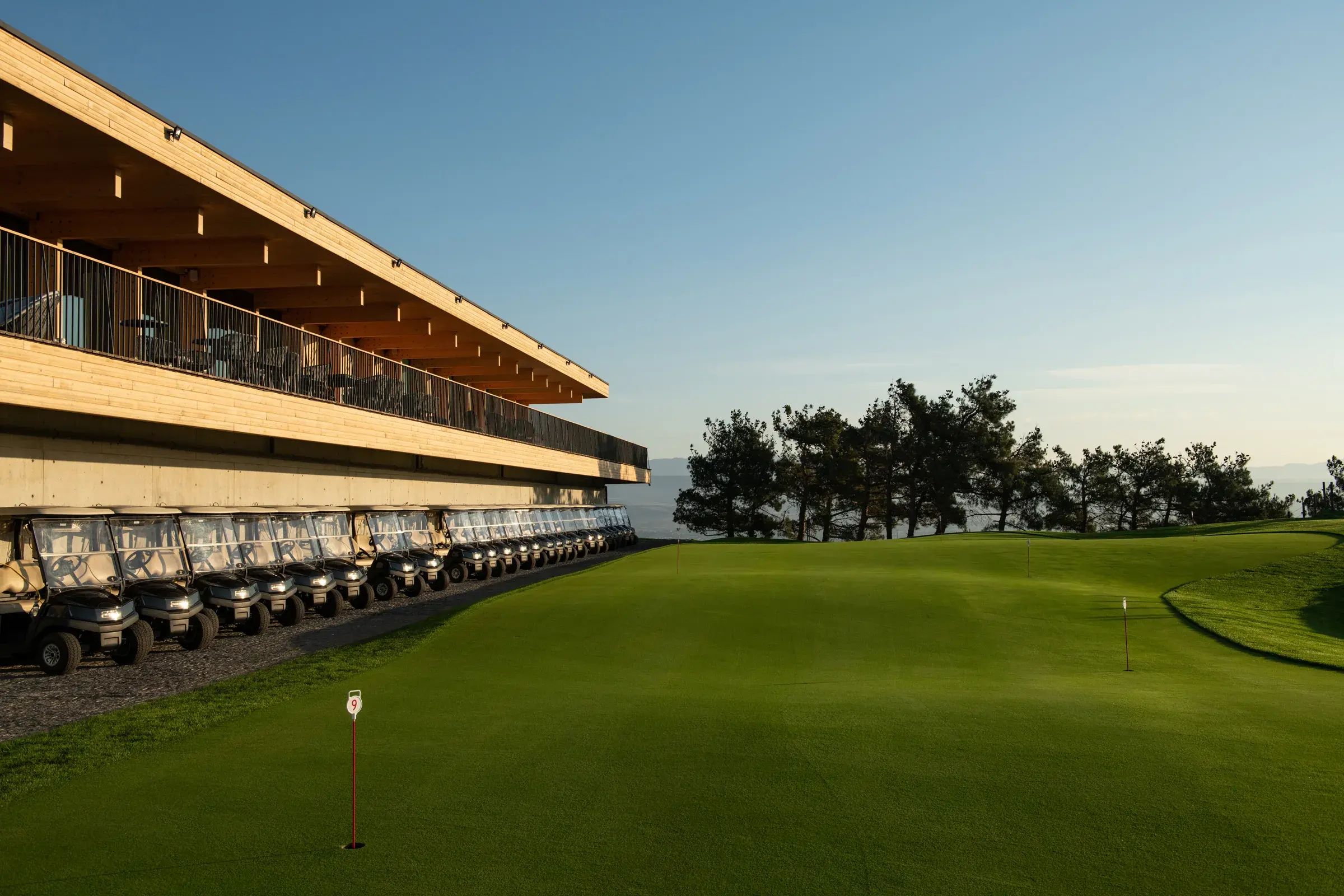 Golf carts beside the Tbilisi Hills clubhouse and practice green