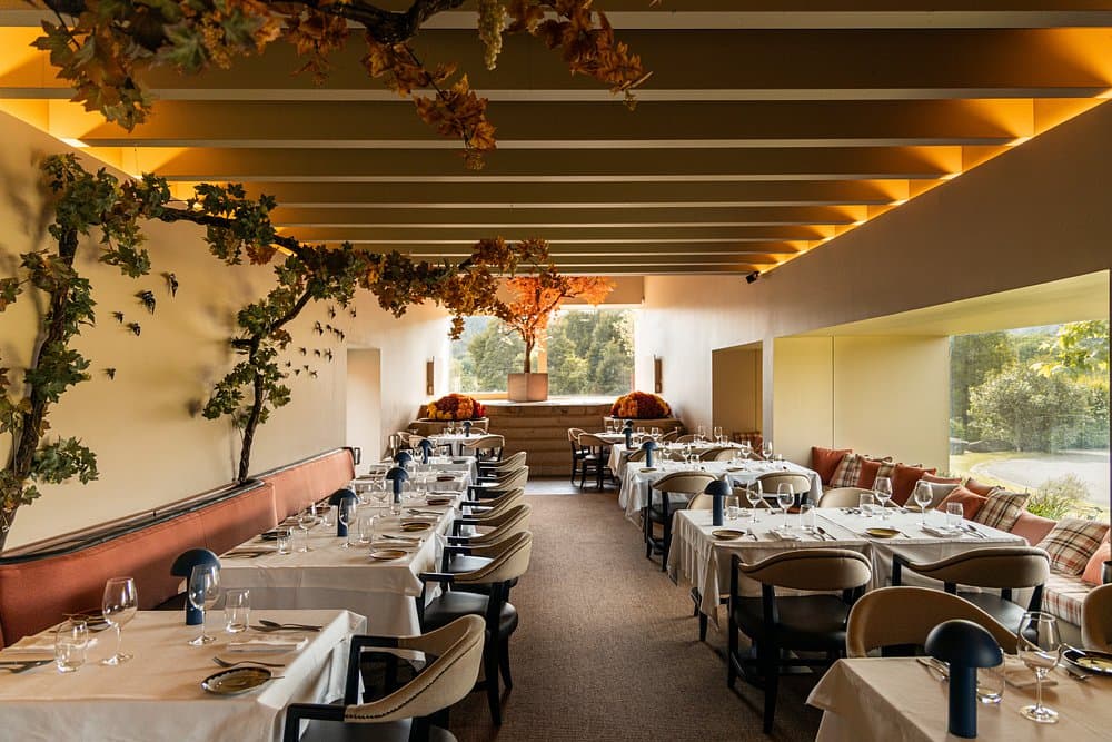 Dining room with tables set for service and a window onto the grounds