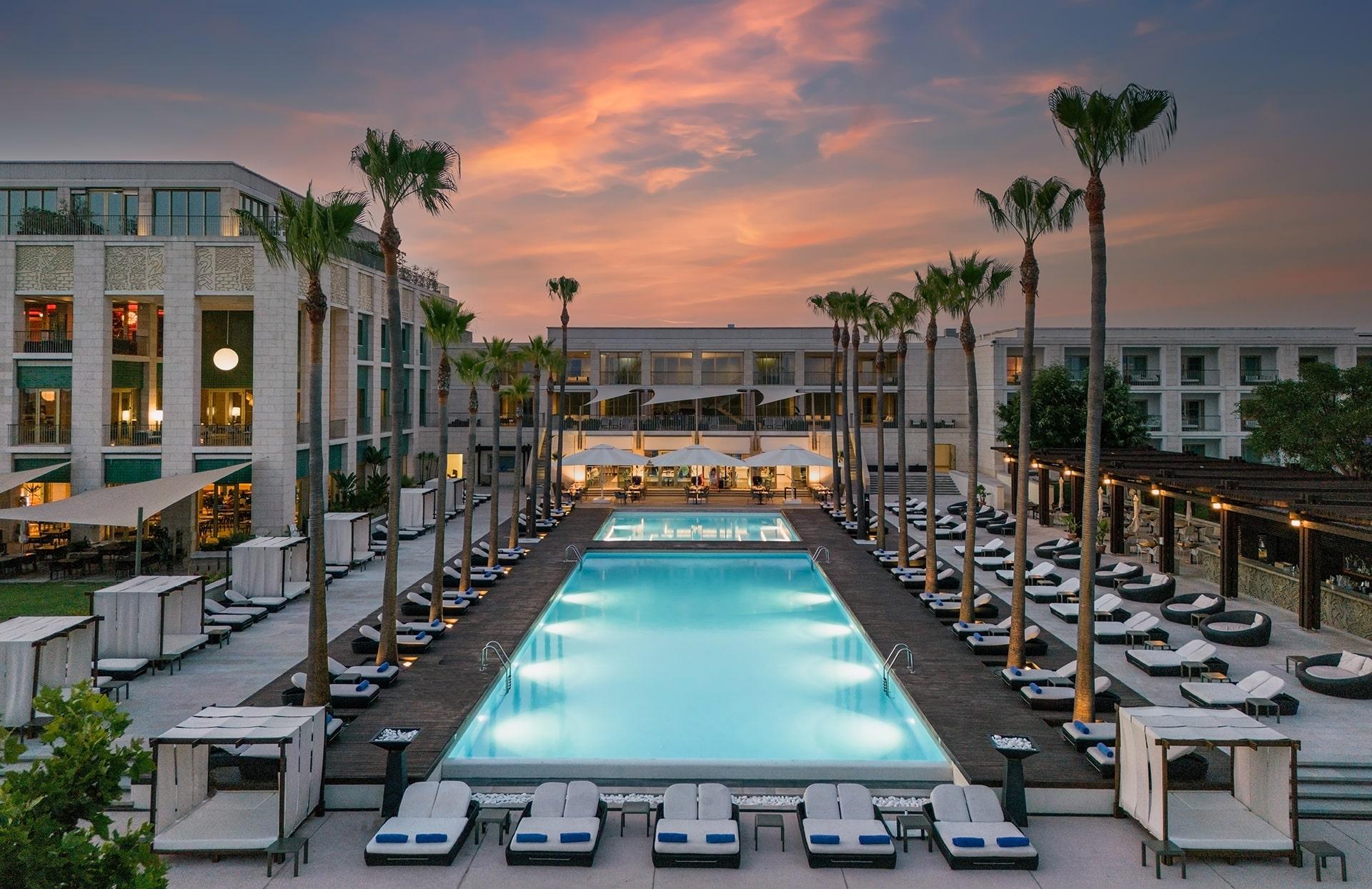 Pool terrace and palms at Victoria Golf Resort & Spa at dusk